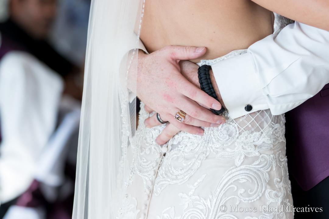 photo of groom's hands around bride's waist